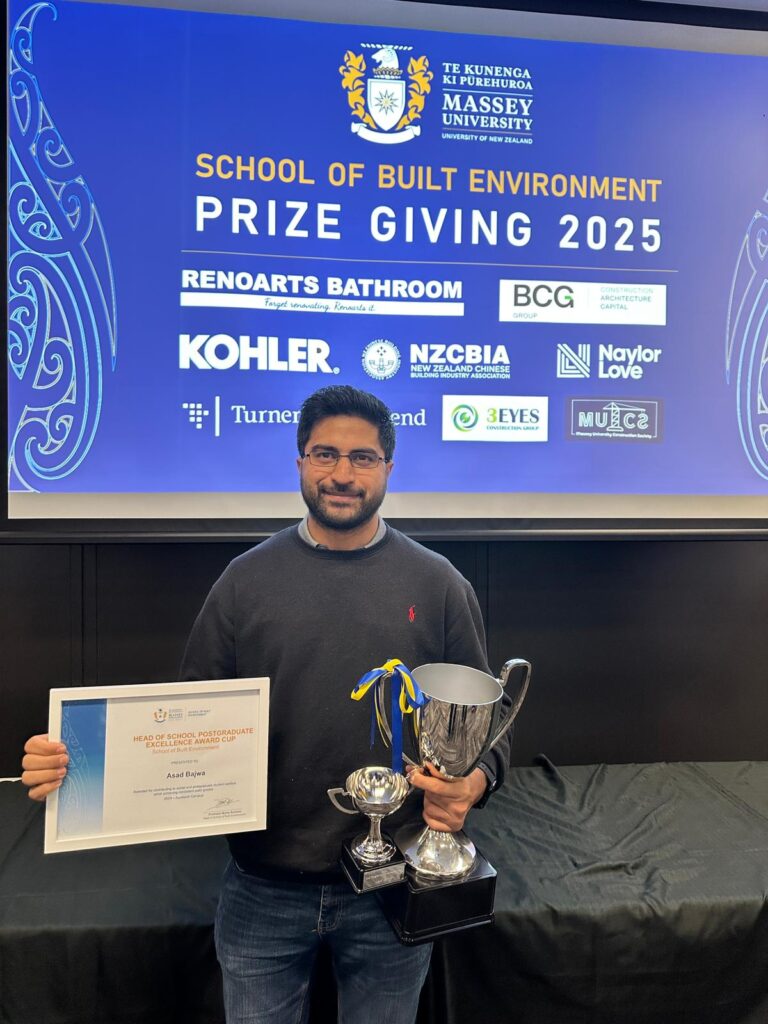 Asad Bajwa holding Head of School Postgraduate Excellence Award Cup at Massey University Prize Giving 2025